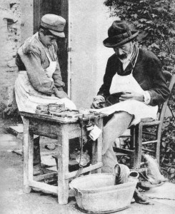 Υποδηματοποιός με τον παραγιό του, γύρω στα 1900 (Προσωπική συλλογή Μάνου Χαριτάτου): Η φιγούρα του «παραγιού» παρέμενε πολύ συνηθισμένη την εποχή αυτή. Ο ανήλικος βοηθός του τεχνίτη μάθαινε την τέχνη πλάι του, και προμήθευε όλη την ανειδίκευτη εργασία που χρειαζόταν. Παλιότερα ήταν δεδομένο ότι ο μαθητευόμενος θα έμενε στου μάστορα, ενσωματωνόμενος στο νοικοκυριό του και κάνοντας δουλειές και του σπιτιού. Στην Αθήνα των αρχών του εικοστού αιώνα, πλέον, αυτή η πρακτική έχει παρακμάσει: πιο κοινό ήταν να διαβάζουμε για τους μικρούς «υπηρέτες» των καφενείων και των παντοπωλείων που κοιμούνταν μέσα στο μαγαζί. Το 1925 ένας 12χρονος υπάλληλος κιγκαλερίας στον Πειραιά και μετέπειτα γνωστός επιχειρηματίας, ο Ελευθέριος Μουζάκης, εγκατέλειψε το αφεντικό του όταν του ζήτησε να του ξύσει το πόδι και να βγάλει βόλτα το παιδί του, μια μέρα που κατ’ εξαίρεση τον τάισε και τον κοίμισε στο σπίτι του. ©Πανεπιστημιακές Εκδόσεις Κρήτης.