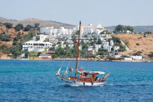 Ενα καϊκι αρμενίζει στα γαλάζια νερά του Αιγαίου, σε κοντινή απόσταση από την Αλικαρνασσό. Πίσω του διακρίνεται ένα από τα δεκάδες resorts που υπάρχουν στην ευρύτερη περιοχή