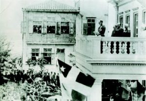 Διακρίνεται η σημαία της Κρητικής Πολιτείας σε ομιλία του Πρίγκηπα Γεωργίου, κατά την ανακήρυξη της ανεξαρτησίας της Κρήτης.